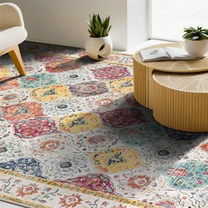 A colorful, patterned rug beneath a round wooden coffee table and a modern white chair, with two decorative plants in white vases nearby.