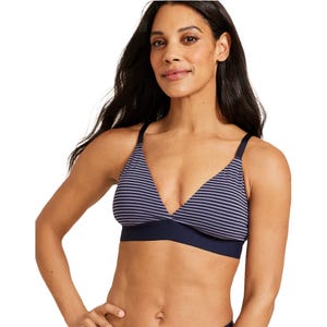 A woman is wearing a blue and white striped bralette with thin shoulder straps and a supportive underband.