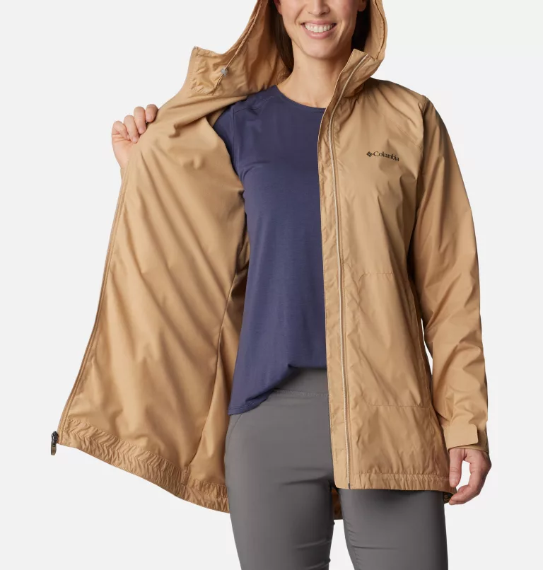 A woman showcasing a tan hooded jacket and a blue t-shirt.