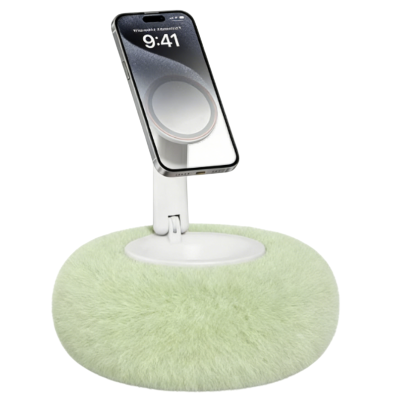 A smartphone is mounted on a fluffy, circular stand with a soft, green surface, resembling a plush cushion.