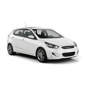 A white compact hatchback car, likely a Hyundai model, with sleek design and modern styling.
