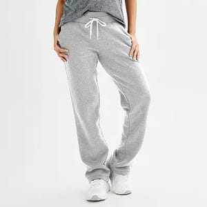 Gray fleece sweatpants with a drawstring waist and relaxed fit, paired with white sneakers.