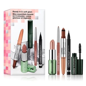 Clinique's \“Ready in 5: Soft Glam\“ kit includes a nude lipstick, brown chubby stick, black eyeliner, and mascara, designed for a quick, soft glam look. Package text is in English and French.