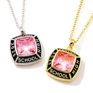 Two class pendants with pink stones and inscriptions reading \“Central High School 2025\“ are shown. One pendant has a silver-tone finish with a silver chain, while the other features a gold-tone finish with a gold chain.