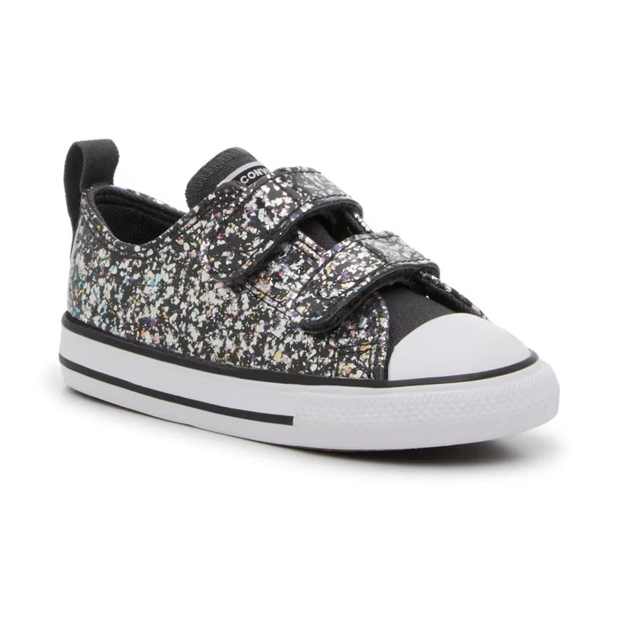Black sneaker with a multicolored speckled design, featuring two Velcro straps and a white rubber toe cap and sole.