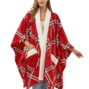 A woman is wearing a red plaid poncho with white sherpa lining and pockets.