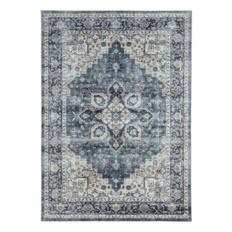 A rectangular area rug with a distressed vintage design, featuring intricate floral and geometric patterns in shades of blue, cream, and gray.