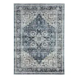 A rectangular area rug with a distressed vintage design, featuring intricate floral and geometric patterns in shades of blue, cream, and gray.
