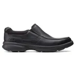A black slip-on shoe with a sturdy rubber sole and leather upper, featuring subtle stitching and a minimalist design.