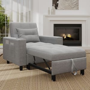 Grey convertible recliner chair with a pull-out footrest, pillow, side pocket, and black metal support, placed on a woven rug in front of a fireplace and a window with sheer curtains.