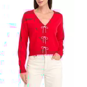 A red V-neck cardigan with three bow ties down the front and long sleeves, paired with cream-colored pants.