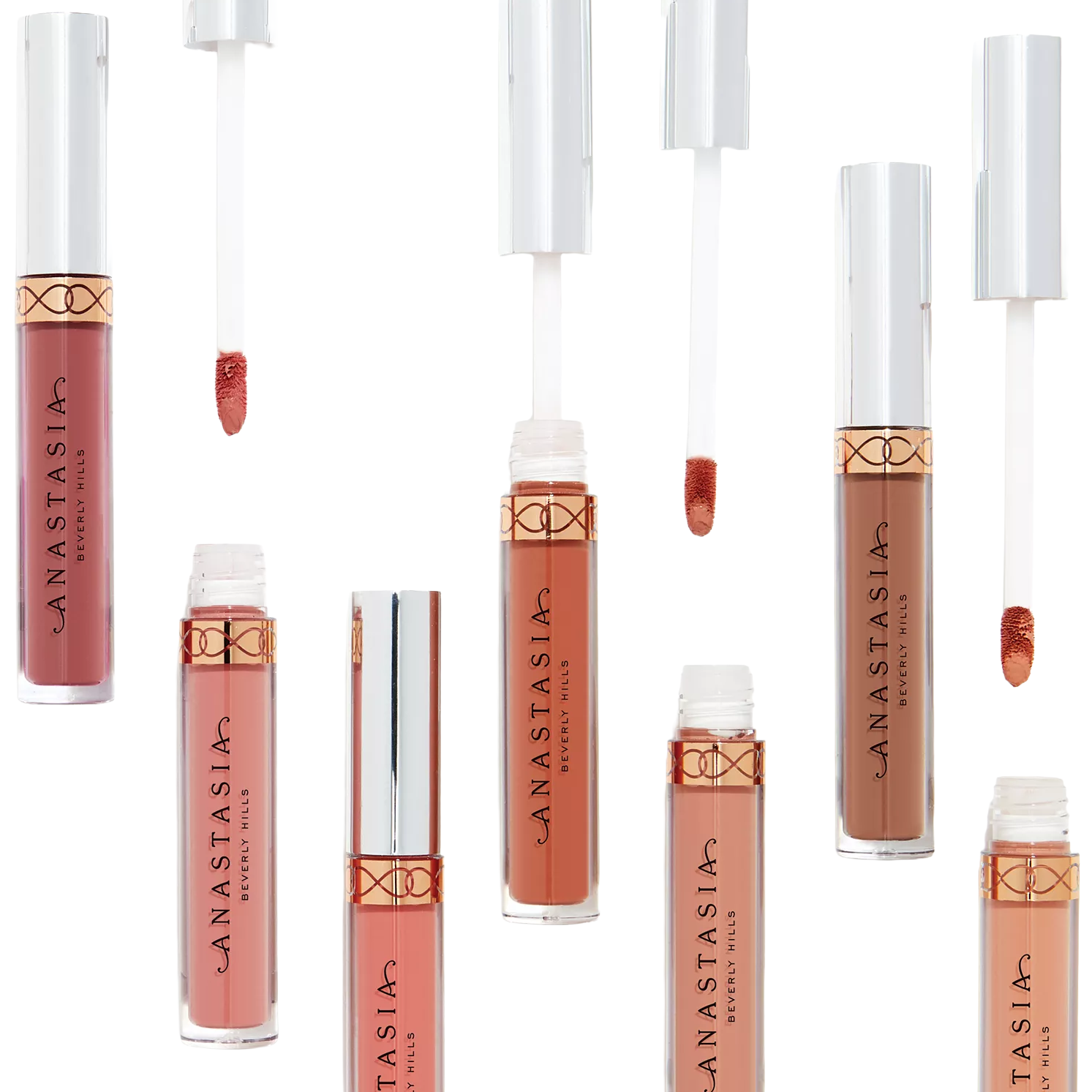 An assortment of Anastasia Beverly Hills liquid lipsticks in various nude and pink shades, featuring sleek transparent tubes with metallic caps and applicators.