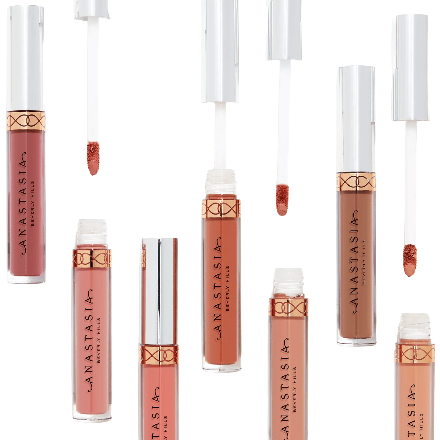 An assortment of Anastasia Beverly Hills liquid lipsticks in various nude and pink shades, featuring sleek transparent tubes with metallic caps and applicators.
