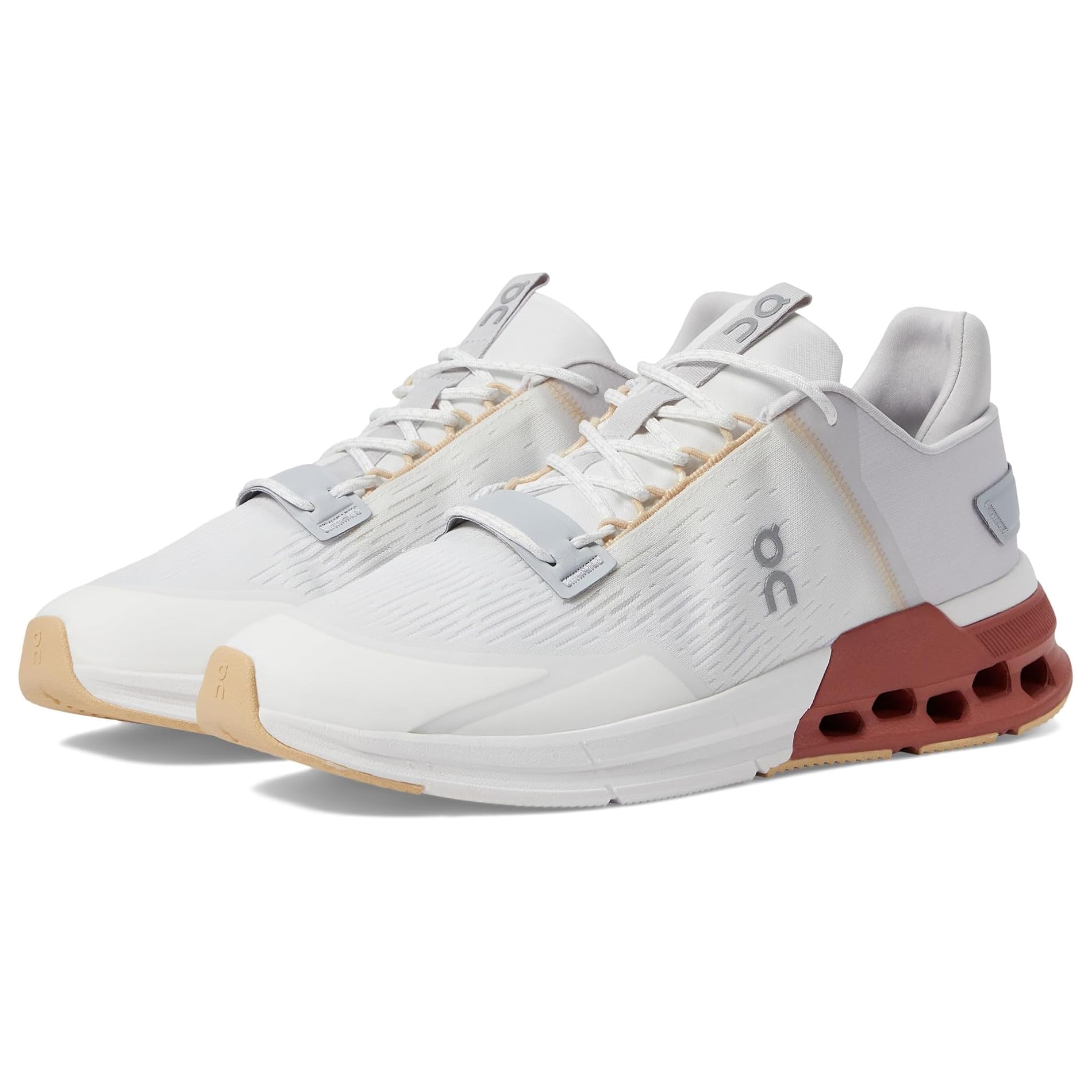 A pair of white sneakers with grey accents and a brown outsole.