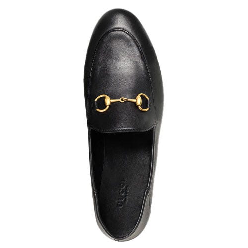 A black leather loafer with a gold horsebit detail on the upper.