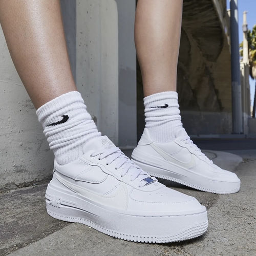 A pair of white high-top sneakers with matching white crew socks.