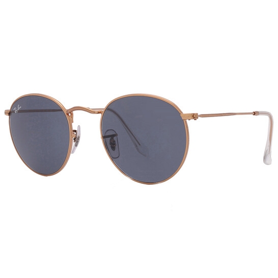 Round Ray-Ban sunglasses featuring a thin gold metal frame, with dark blue lenses and clear nose pads. The design is classic and minimalist.