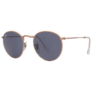 Round Ray-Ban sunglasses featuring a thin gold metal frame, with dark blue lenses and clear nose pads. The design is classic and minimalist.