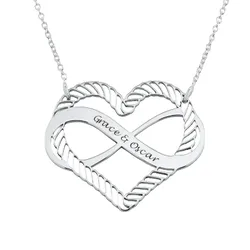 A silver heart-shaped pendant with an infinity symbol design, featuring the engraved names \“Grace & Oscar,\“ attached to a delicate chain.