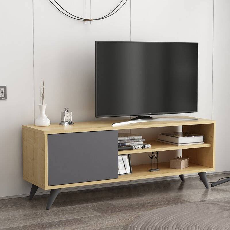 A modern TV stand with a mix of open shelves and a closed gray cabinet, accompanied by a flat-screen TV on top and various decorative items.