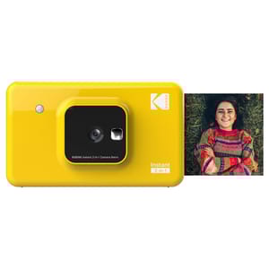 Yellow Kodak Mini Shot 2 Instant Camera featuring a 2-in-1 design for capturing and printing photos. It includes an example print showing a person smiling in a colorful sweater.