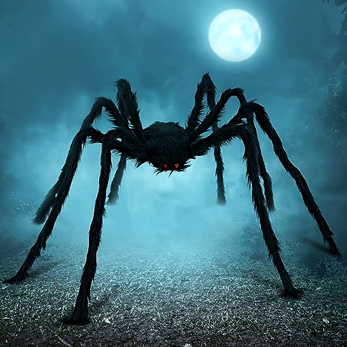 A large, hairy black spider decoration with red eyes is posed against a foggy, moonlit background.