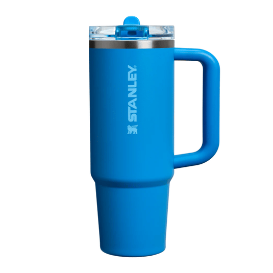 Blue Stanley travel mug with a handle and a clear lid.