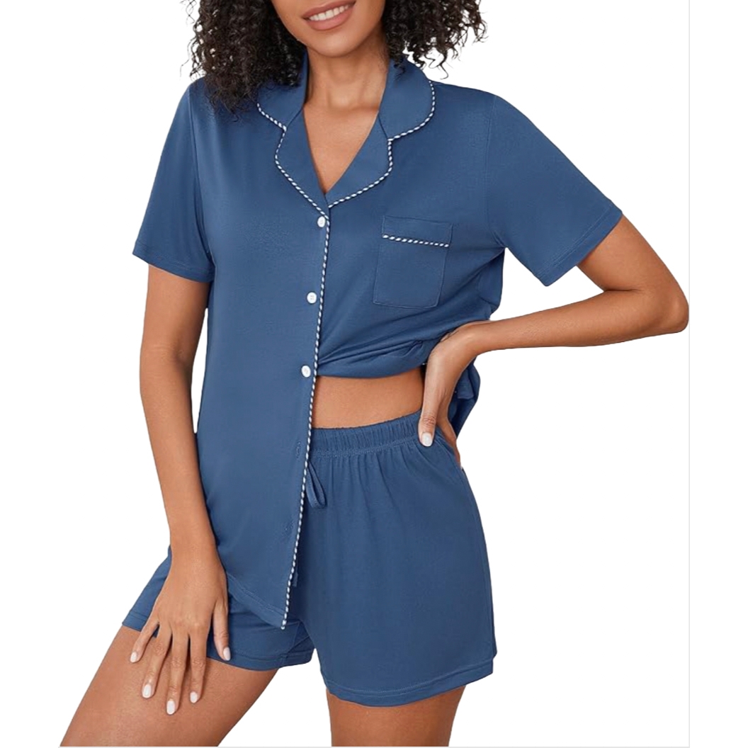 A woman is wearing a blue pajama set with white trim, featuring a short-sleeve button-up top and elastic waist shorts.
