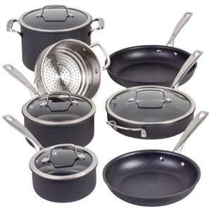 A set of black non-stick cookware with stainless steel handles, including various pots, pans, and a steamer insert, all with glass lids.