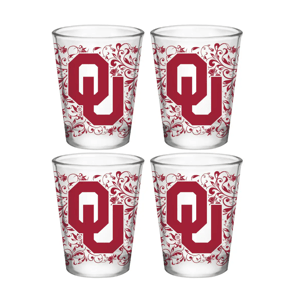 Four shot glasses featuring a decorative design with the \“OU\“ logo in red, indicative of the University of Oklahoma.