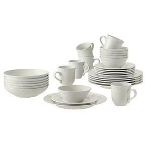 White dinnerware set including plates of various sizes, bowls, and cups with saucers, all with a ridged design.