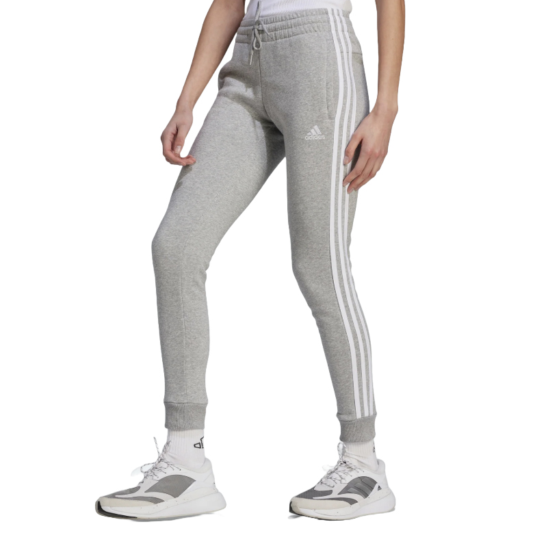 Gray Adidas Essentials Fleece Pants with iconic three white stripes down the sides, elastic waistband, and cuffs. Paired with white Adidas sneakers.