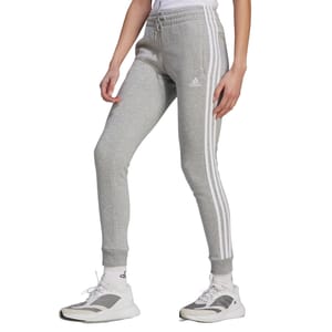 Gray Adidas Essentials Fleece Pants with iconic three white stripes down the sides, elastic waistband, and cuffs. Paired with white Adidas sneakers.