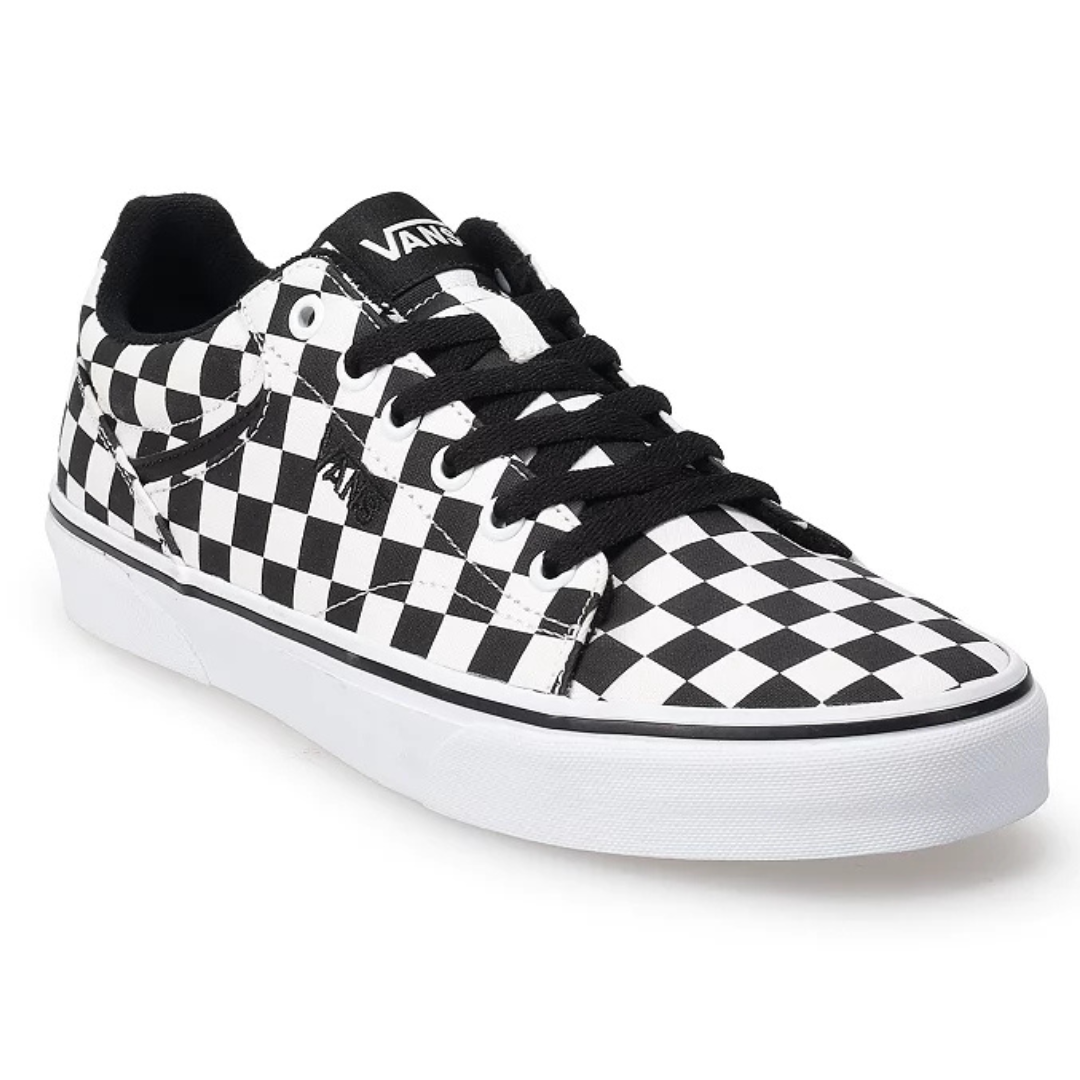 Black and white checkerboard-patterned Vans sneakers with black laces, a low-top design, and white rubber soles. The brand logo is visible on the tongue.