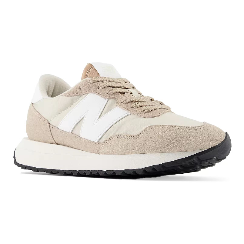 A beige and white New Balance sneaker with a suede and fabric upper, featuring a black sole and the brand's signature \“N\“ logo.