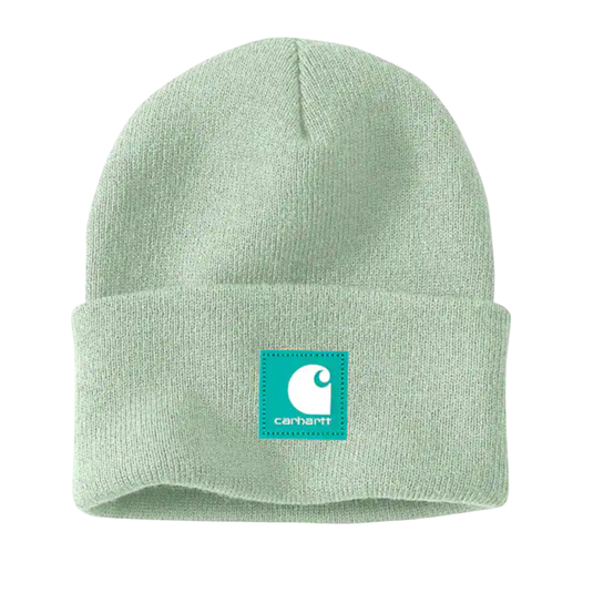 A light green Carhartt beanie featuring a teal logo patch with the Carhartt emblem and name on the front cuff.