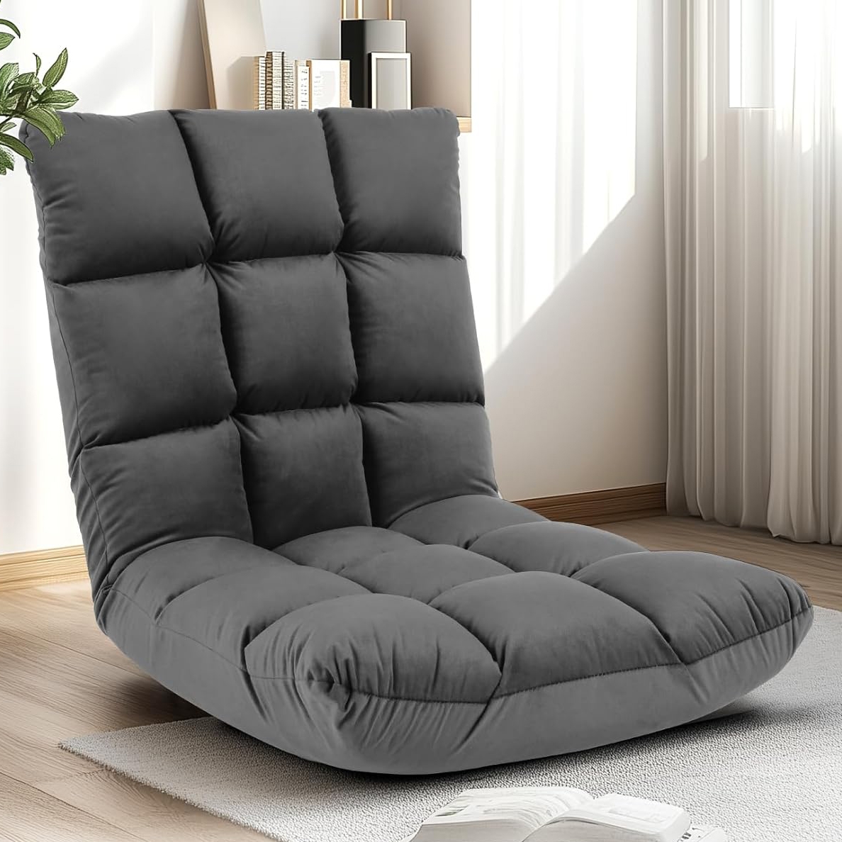 Gray floor chair with a padded, tufted design, positioned on a light-colored rug in a room with natural light and minimal decor.