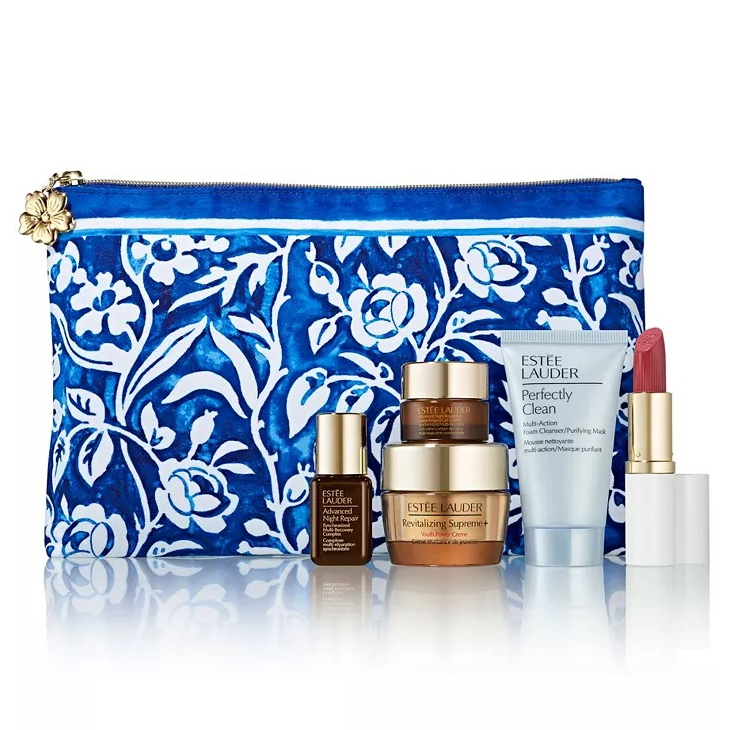 A blue floral cosmetic bag contains Estée Lauder products: Advanced Night Repair serum, Revitalizing Supreme+ creme, Perfectly Clean cleanser, and a lipstick.