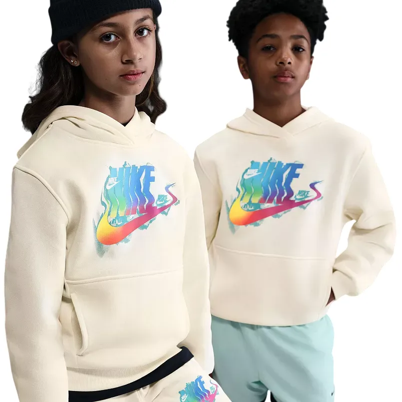 Two kids wearing cream Nike hoodies with a colorful logo design. One is also wearing matching shorts, while the other pairs the hoodie with light blue pants.