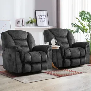 Two plush, dark gray recliners are positioned on a geometric-patterned rug in a well-lit room, complemented by a small round side table holding a tea set.