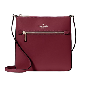 A maroon Kate Spade New York crossbody bag featuring a front zipper pocket, brand logo, and an adjustable strap.
