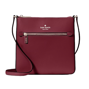 A maroon Kate Spade New York crossbody bag featuring a front zipper pocket, brand logo, and an adjustable strap.