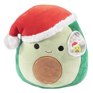 A plush toy shaped like an avocado wearing a Santa hat, with a tag indicating the character's name is Austin.