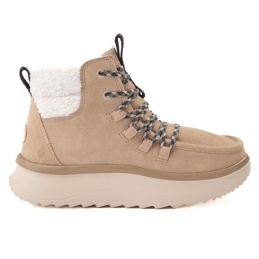 A beige suede boot with black and white laces, a plush white fleece lining, and a thick, textured sole.
