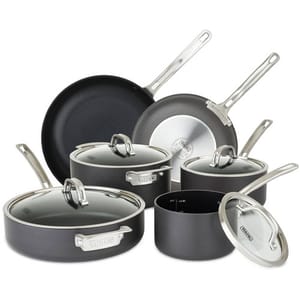 Cookware set including two frying pans and four lidded pots, all in non-stick, dark material with stainless steel handles.