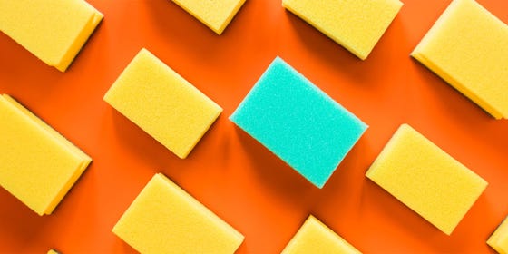 An orange background with various yellow sponges and one blue sponge.