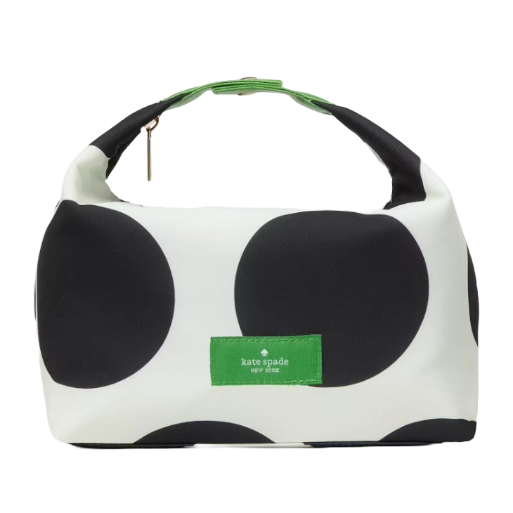 A Kate Spade New York handbag featuring large black polka dots on a white background, with a green top handle and a green label on the front.
