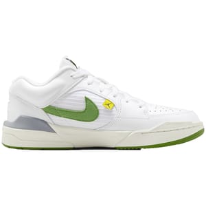 White sneakers with green and yellow accents, featuring a prominent Nike swoosh logo and a yellow Jordan emblem on the Velcro strap.