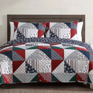 A queen-size quilt set with a patchwork design featuring red, navy, green, and white colors, and geometric and floral patterns. Includes two matching pillow shams.