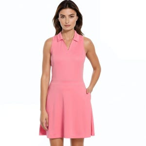 A woman wears a sleeveless pink dress with a V-neck and a fitted waist, made from a lightweight fabric.